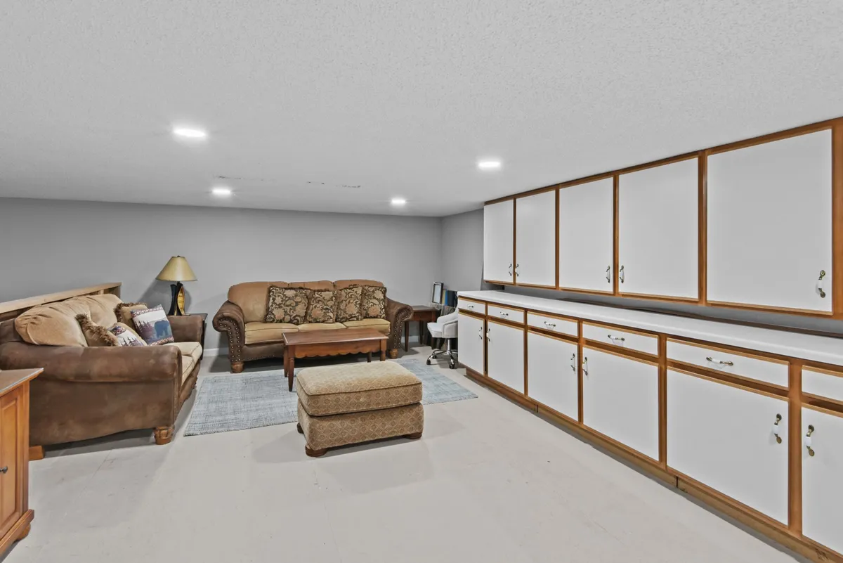 A comfortable, inviting loft lounge area with a plush sofa, ottoman, soft lighting, and cabinets. The space is perfect for reading, unwinding, or late-night chats, offering a relaxing contrast to the more energetic game room below.